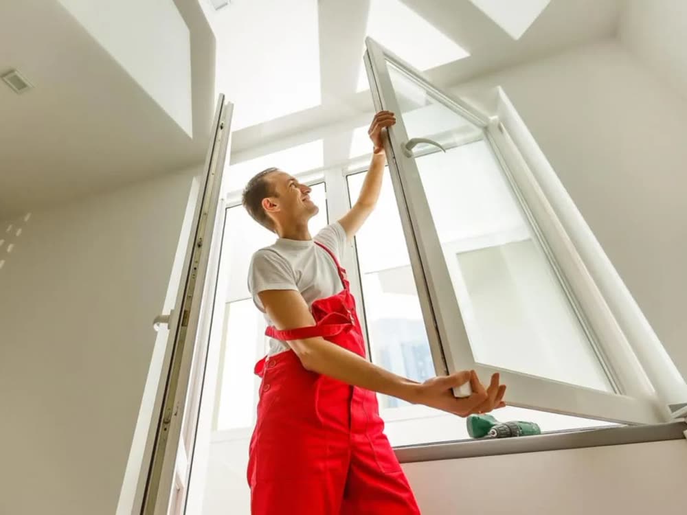 Tecnico al lavoro sull'anta di una finestra appena installata