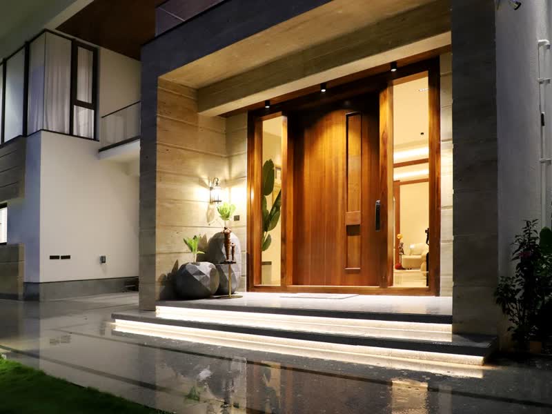 Ingresso di una casa moderna con portone in legno illuminato